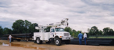 Northeast Texas Power crew with poles and drilling rig